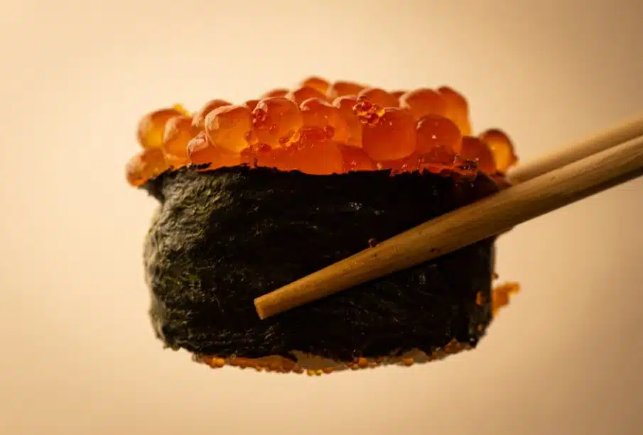 a close up of a sushi with chopsticks
