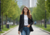 Femme souriante dans un parc urbain verdoyant