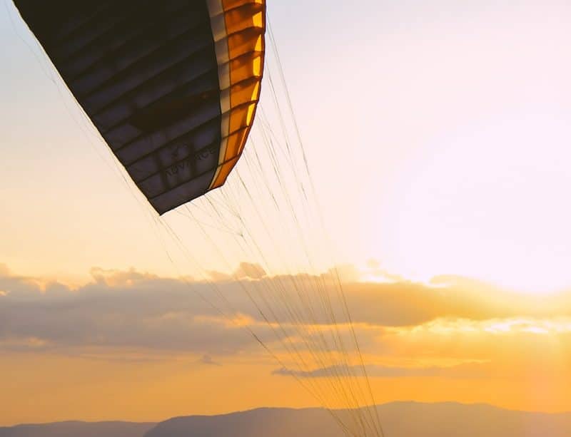 silhouette of person on parachute during sunset